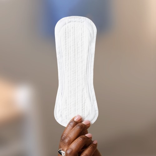 Hand holding up a TENA Pad  Hand holding up a TENA Pad
